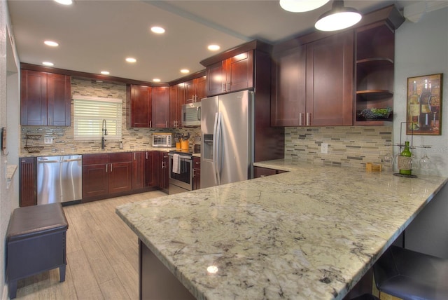 kitchen featuring decorative backsplash, sink, kitchen peninsula, and stainless steel appliances