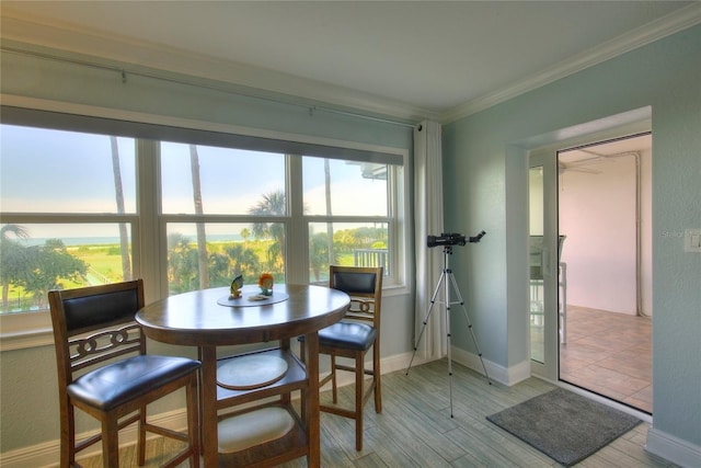 dining space featuring light wood-type flooring and ornamental molding