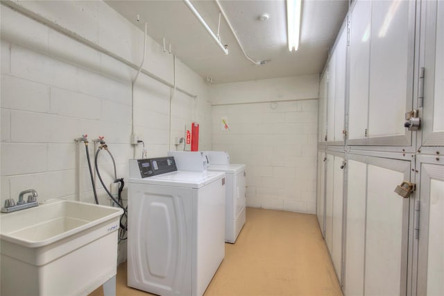 laundry area with washer and dryer, cabinets, and sink