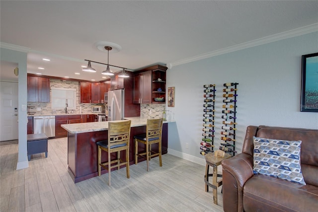 kitchen with kitchen peninsula, backsplash, ornamental molding, stainless steel appliances, and pendant lighting