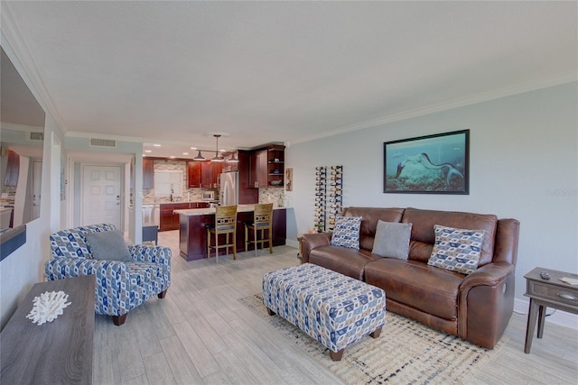 living room featuring light hardwood / wood-style flooring and ornamental molding