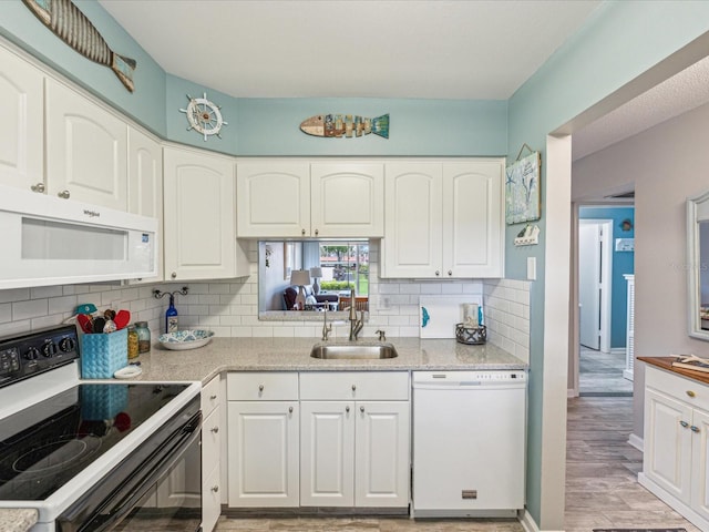 kitchen with backsplash, white cabinetry, white appliances, and sink