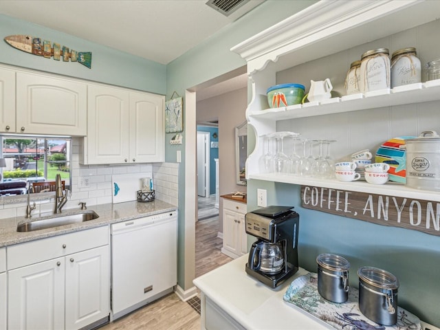 kitchen featuring white cabinets, sink, light wood-type flooring, and white dishwasher