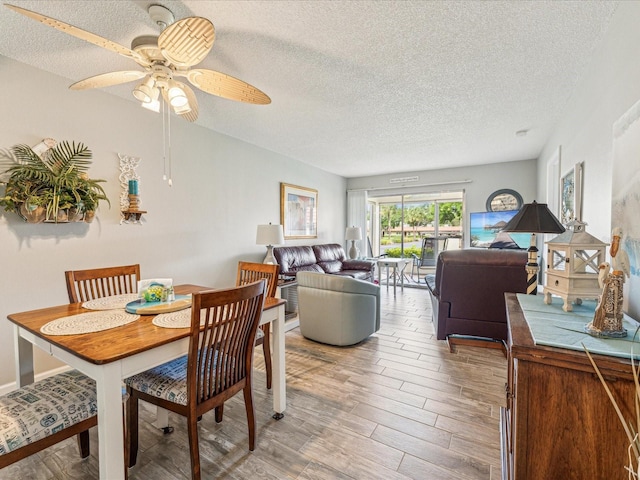 dining room with ceiling fan, hardwood / wood-style flooring, and a textured ceiling