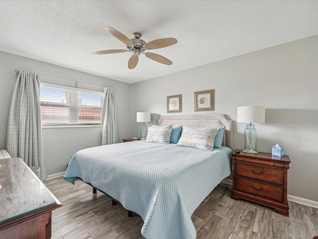 bedroom featuring wood-type flooring, ceiling fan, and a textured ceiling