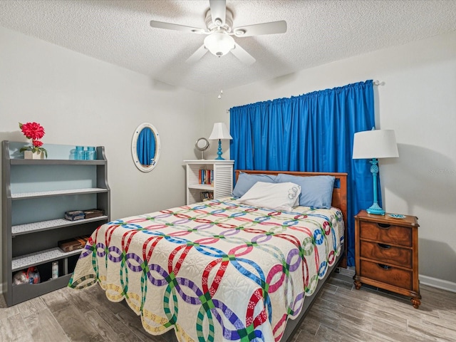 bedroom with wood-type flooring, ceiling fan, and a textured ceiling