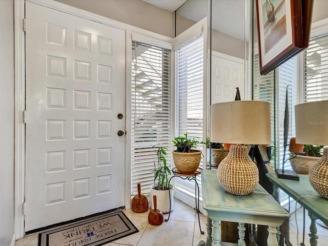 tiled entrance foyer with a healthy amount of sunlight