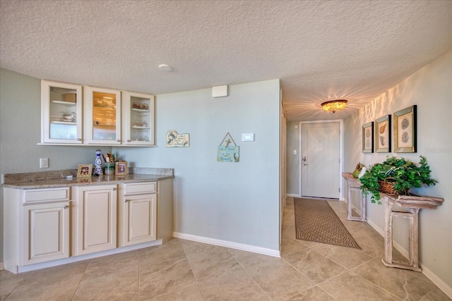 interior space featuring a textured ceiling and light tile flooring