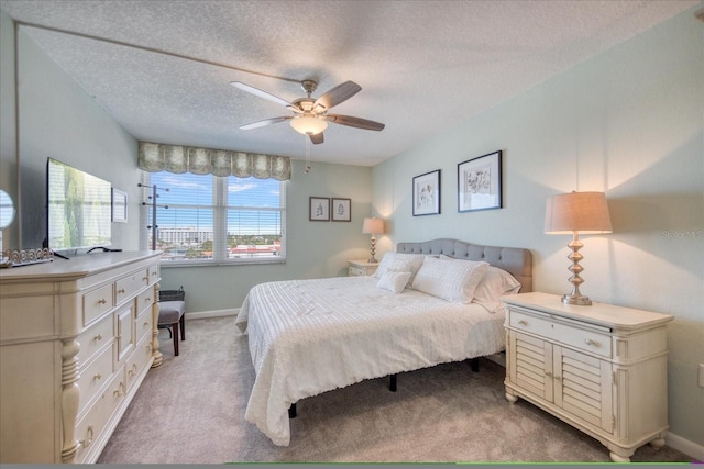 carpeted bedroom with a textured ceiling and ceiling fan