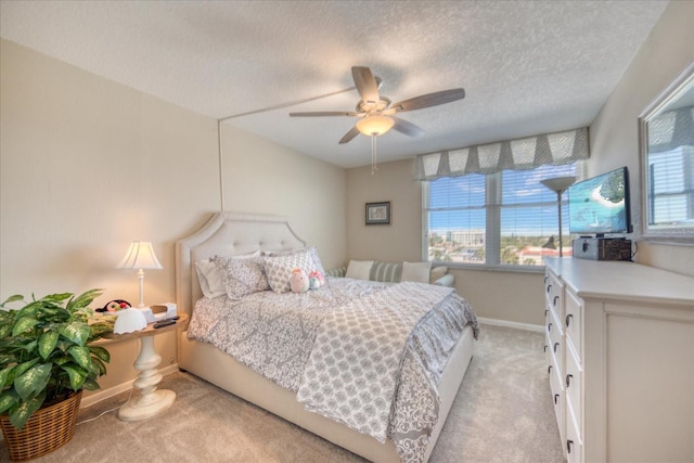 carpeted bedroom with ceiling fan and a textured ceiling