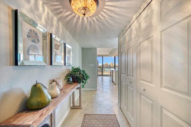 hall featuring a textured ceiling and light tile flooring