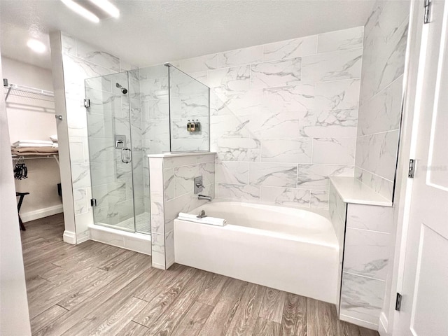 bathroom with hardwood / wood-style floors and shower with separate bathtub