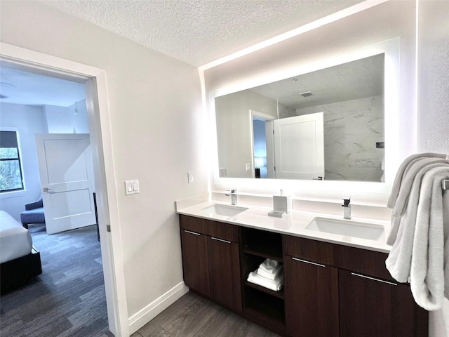 bathroom with hardwood / wood-style floors, vanity, and a textured ceiling