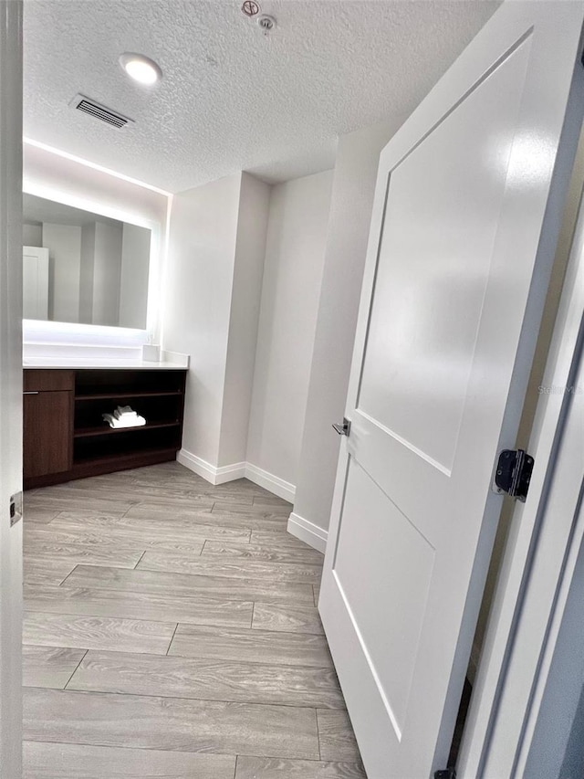 bathroom featuring a textured ceiling and vanity