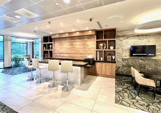 bar with built in shelves, expansive windows, and light tile patterned floors