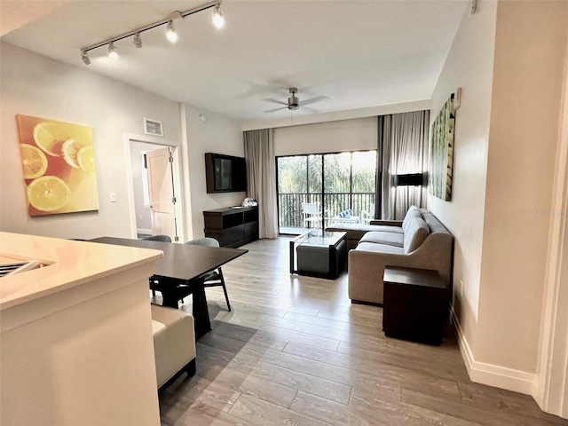 living room featuring ceiling fan and light hardwood / wood-style flooring