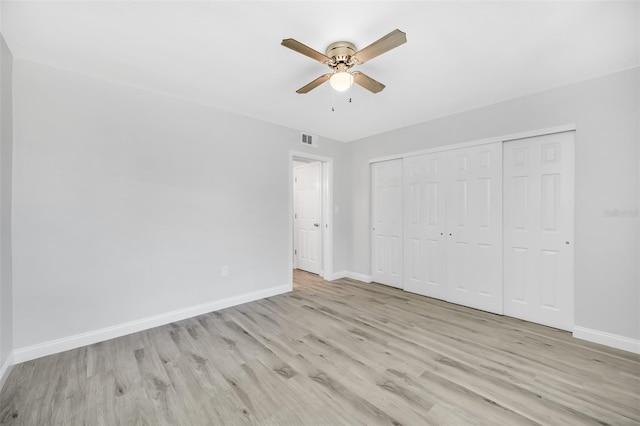 unfurnished bedroom featuring ceiling fan, light hardwood / wood-style floors, and a closet