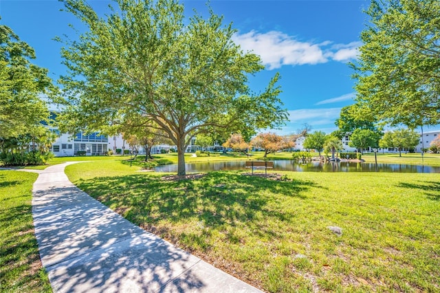 view of property's community featuring a lawn and a water view