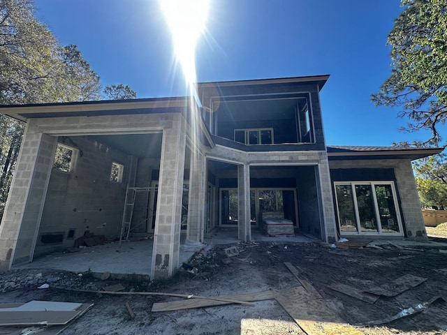 rear view of property with concrete block siding and a patio