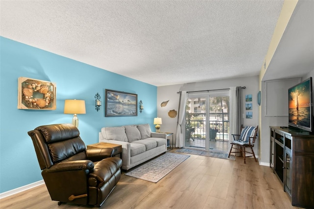 living room featuring light hardwood / wood-style floors and a textured ceiling