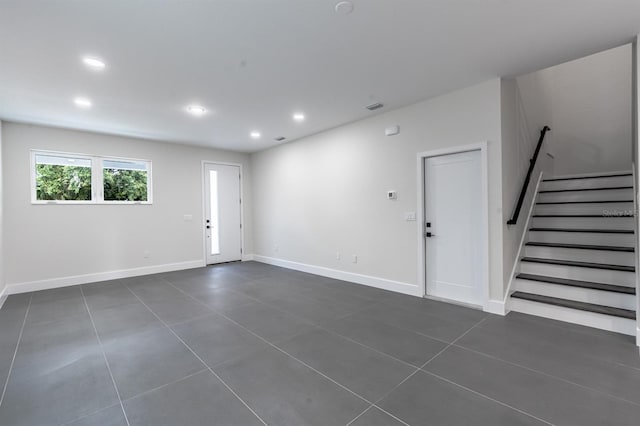 spare room featuring dark tile flooring