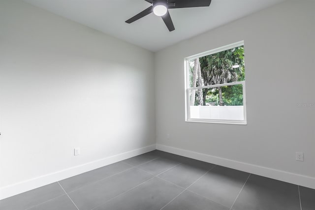 tiled spare room with ceiling fan