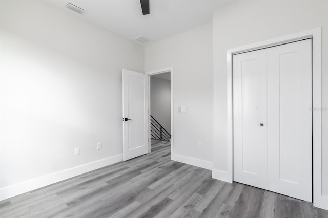 unfurnished bedroom with a closet, ceiling fan, and light wood-type flooring