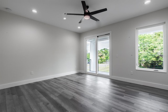 spare room featuring dark hardwood / wood-style flooring, ceiling fan, and a wealth of natural light