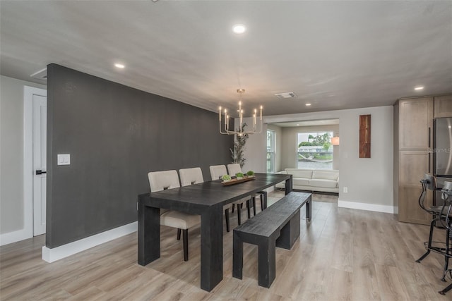 dining area featuring a chandelier and light hardwood / wood-style flooring