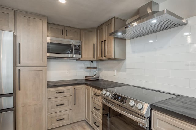 kitchen featuring tasteful backsplash, wall chimney exhaust hood, and stainless steel appliances