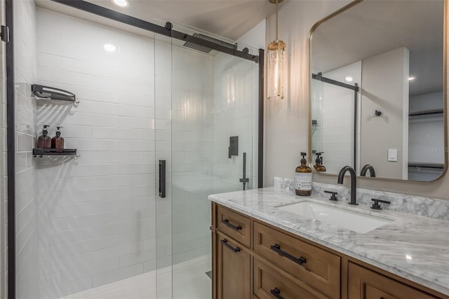 bathroom with a shower with shower door and vanity