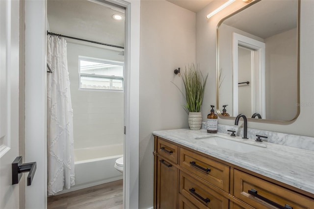 full bathroom featuring oversized vanity, hardwood / wood-style flooring, toilet, and shower / bathtub combination with curtain