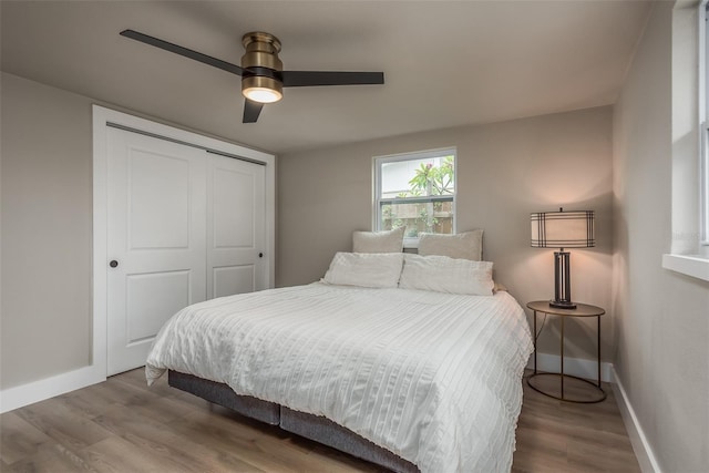 bedroom with a closet, hardwood / wood-style floors, and ceiling fan