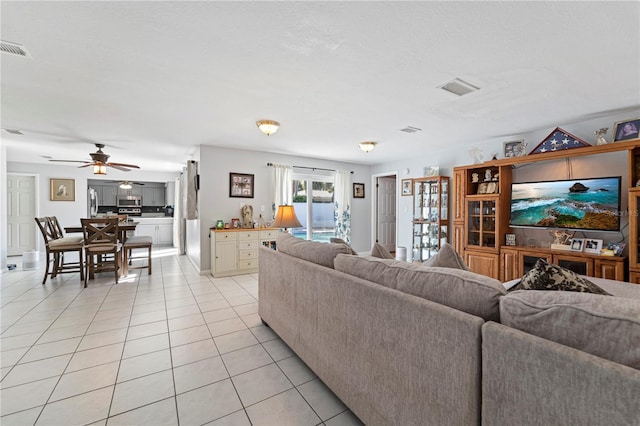 tiled living room featuring ceiling fan