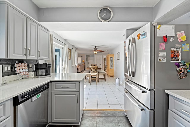 kitchen featuring backsplash, ceiling fan, light tile flooring, appliances with stainless steel finishes, and gray cabinets