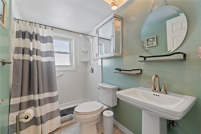 bathroom featuring curtained shower, toilet, tile floors, and sink