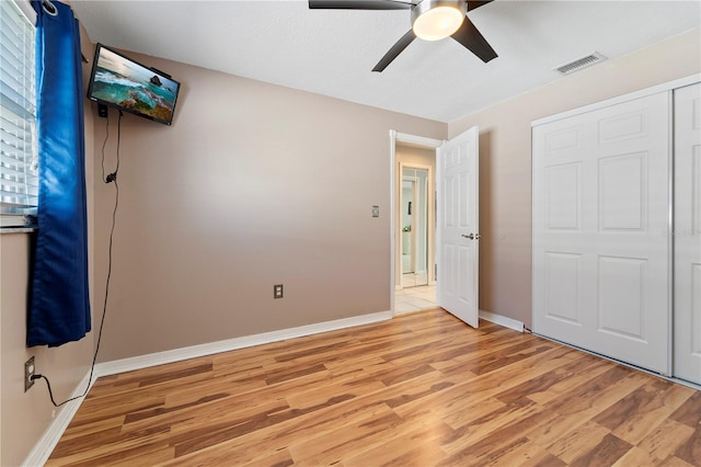 unfurnished bedroom featuring a closet, ceiling fan, and light hardwood / wood-style flooring