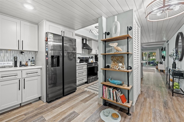 kitchen featuring fridge with ice dispenser, white cabinetry, black range with electric stovetop, wall chimney range hood, and light hardwood / wood-style flooring