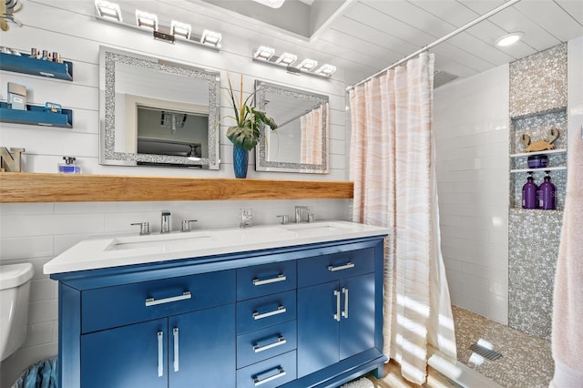 bathroom with vanity, curtained shower, toilet, and tile walls