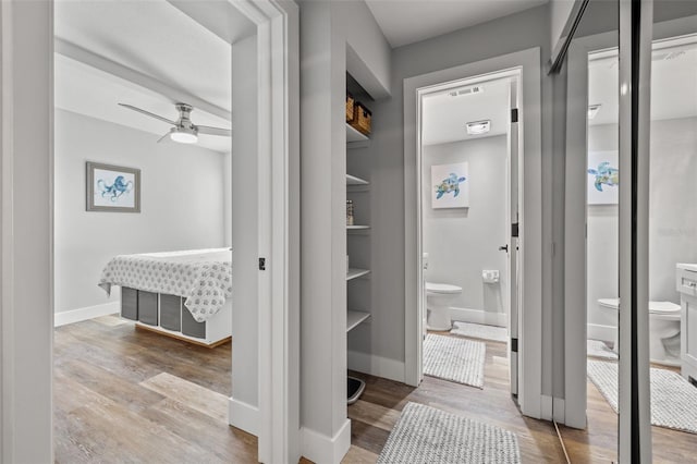 bathroom with built in shelves, ceiling fan, toilet, and hardwood / wood-style flooring