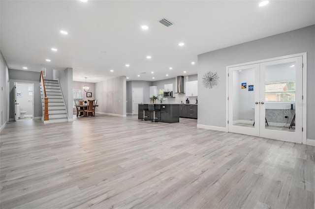 unfurnished living room featuring light hardwood / wood-style flooring and french doors