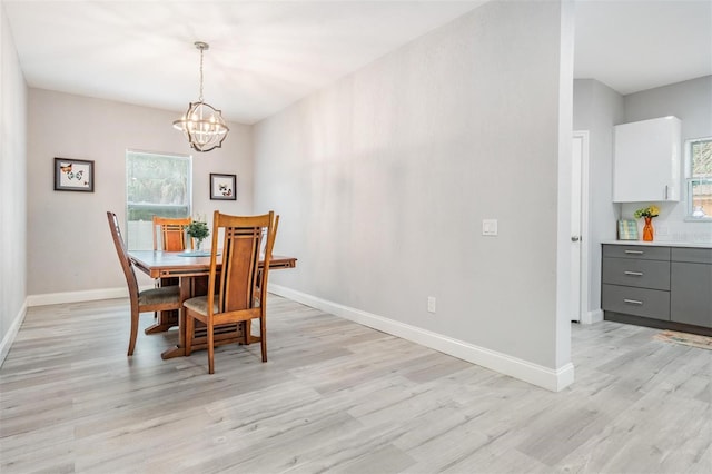 dining room featuring a chandelier, a healthy amount of sunlight, and light hardwood / wood-style flooring