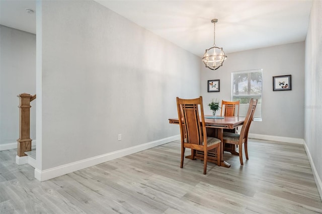 dining room with an inviting chandelier and light hardwood / wood-style flooring