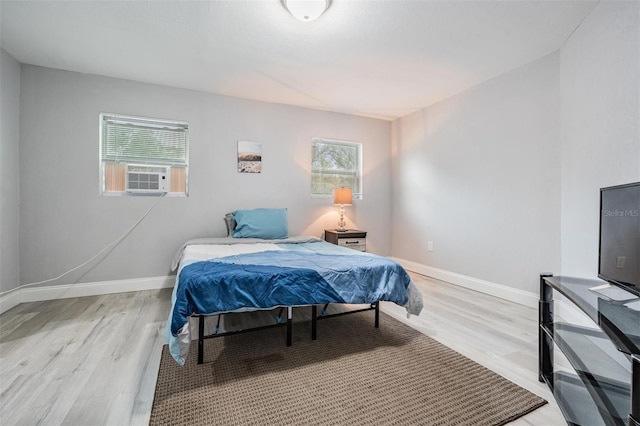 bedroom with multiple windows and light wood-type flooring