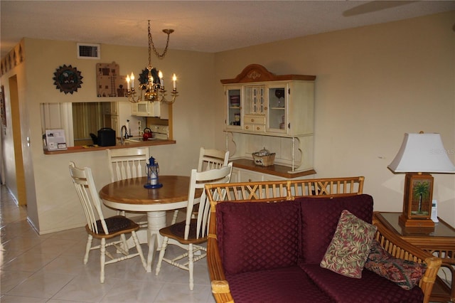 dining room with a chandelier, sink, and light tile flooring