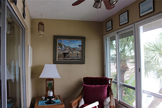 sitting room with ceiling fan and a textured ceiling