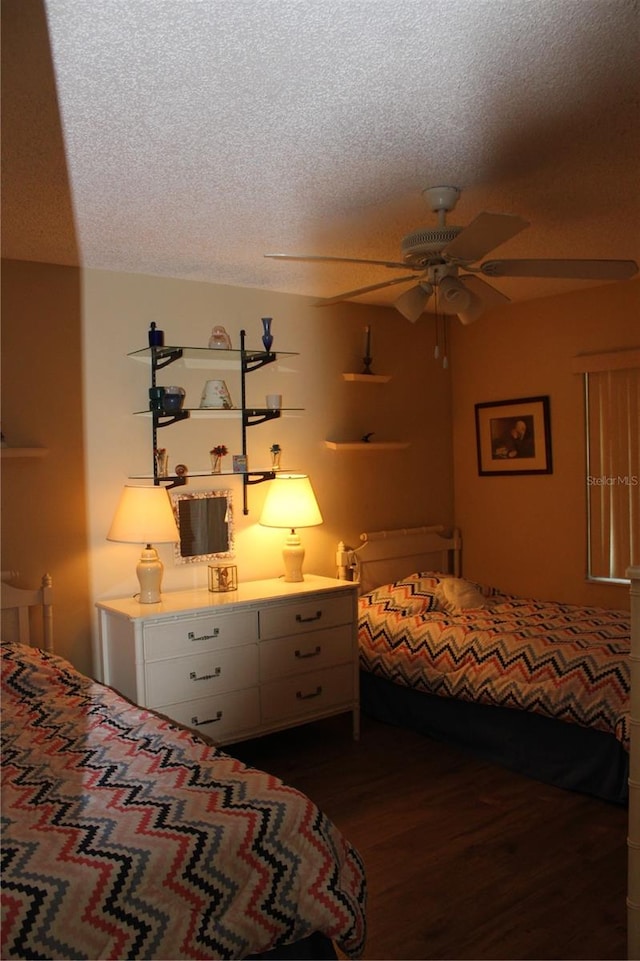 bedroom with dark hardwood / wood-style flooring, ceiling fan, and a textured ceiling