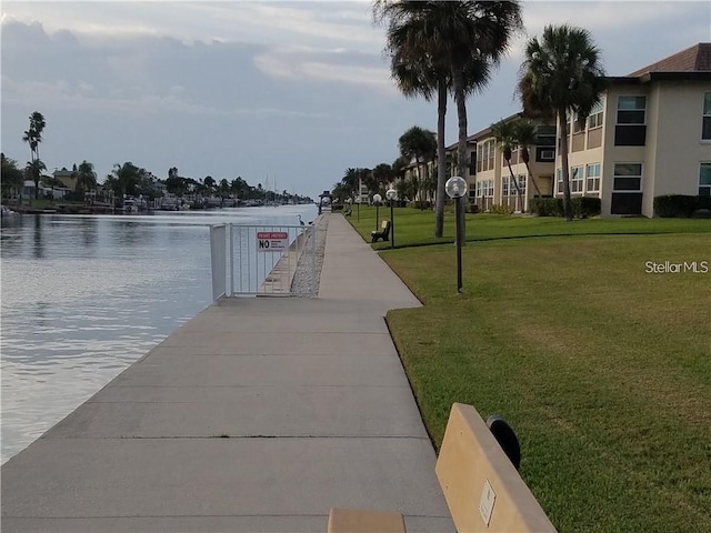 dock area with a water view and a yard