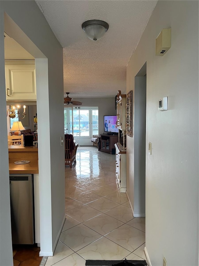 corridor with baseboards and a textured ceiling