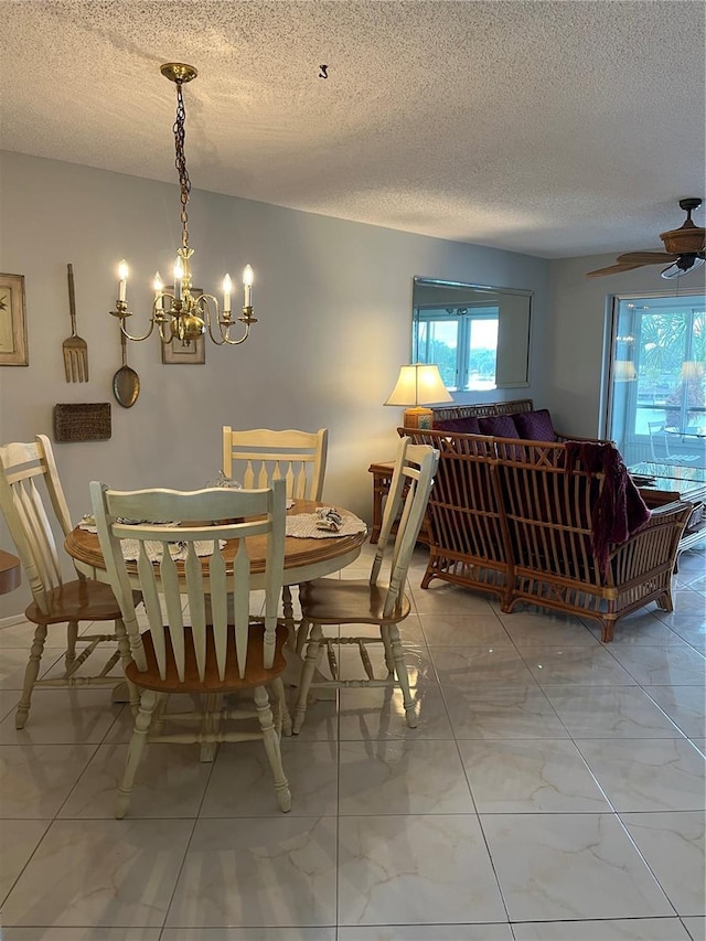 dining area with a chandelier, marble finish floor, a textured ceiling, and plenty of natural light